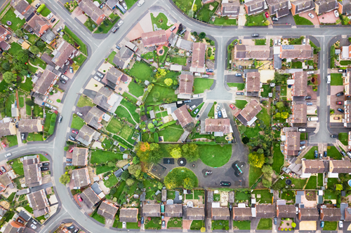 An aerial photograph of a neighbourhood, with many houses and a few roads