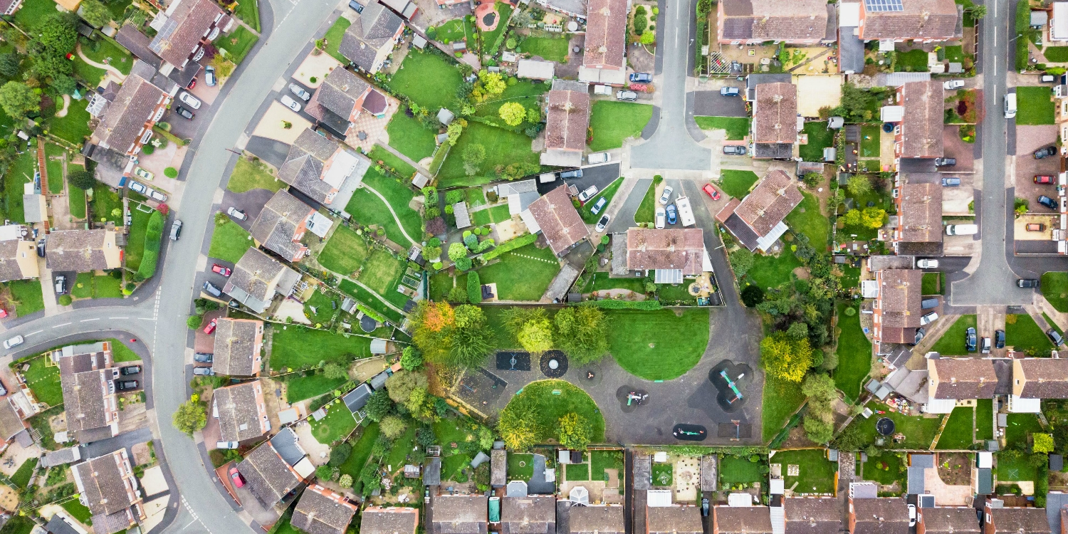 An aerial photograph of a neighbourhood, with many houses and a few roads